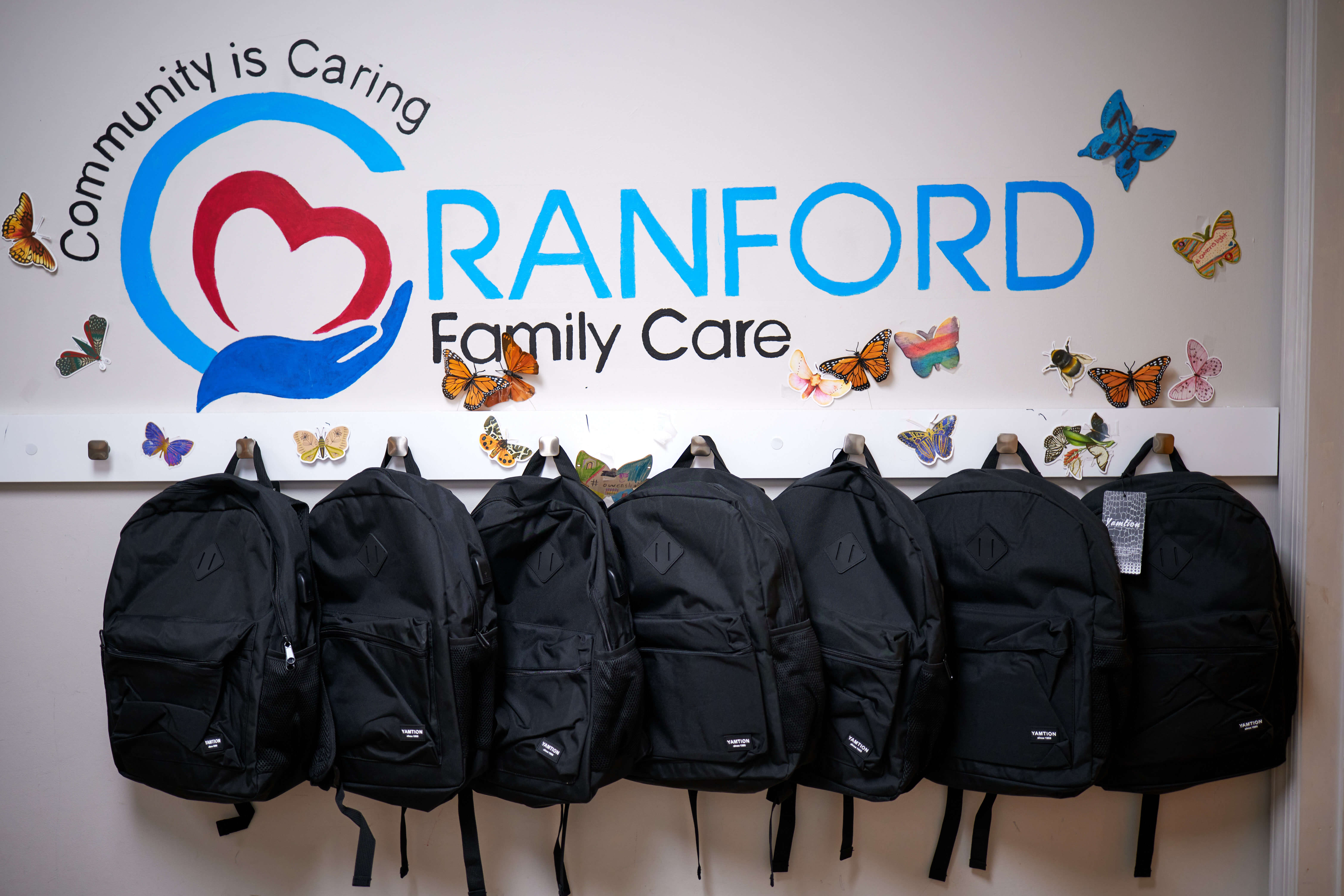 Backpacks hung up under the Cranford Family Care logo.